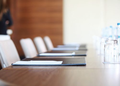 A meeting room with notepads and glasses with water