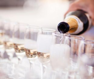 A person pouring champagne into glasses