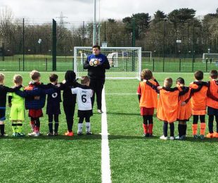 Children in two teams watching the coach