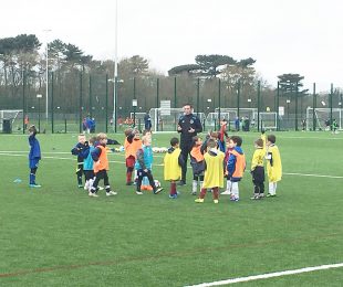 Everton coach training children on the 4k weather pitches