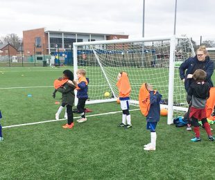 Children learning how to play football at the Vauxhall Sports Club