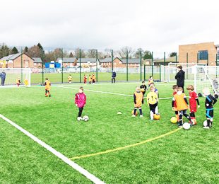 Children playing football on the pitch