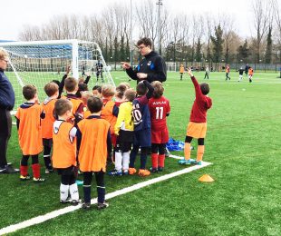 Coaches training children on the football pitch