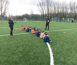 Children sitting down on the 4k football pitch