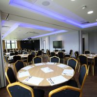 Seats surrounded by round tables setup for a corporate event