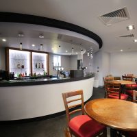 table and chairs next to the bar