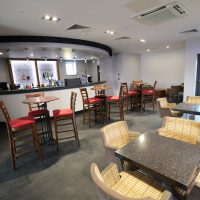 Bar stools and chairs around tables next to the bar in the function room