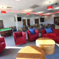 Chairs and sofas and a snooker table in the function room at Vauxhall Sports Club